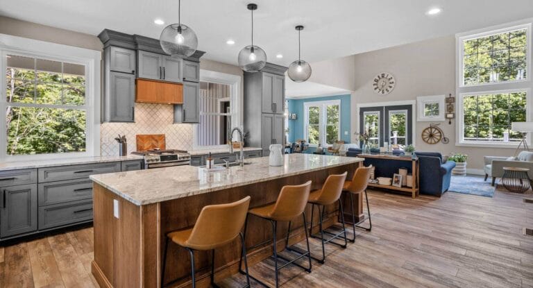 Kitchen with brown wood and grey cabinet color scheme. Eating island with chairs