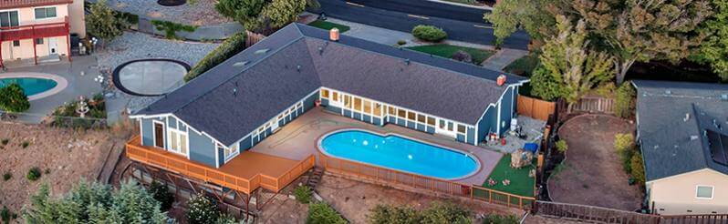 Aerial shot of large home with swimming pool overlooking hills
