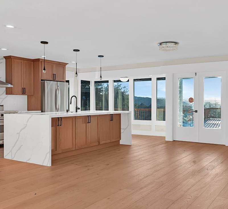 Kitchen with white and wood color scheme. Patio seen through the glass door.