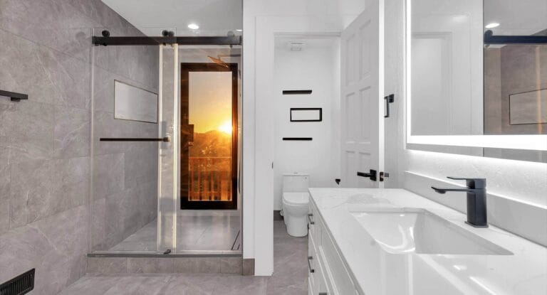 Bathroom with standing shower that has a glass door leading to the outside balcony