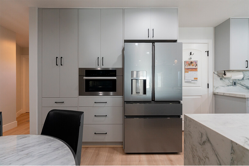 stylish remodeled white marble kitchen with a modern fridge