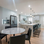 modern stylish kitchen with white marble countertops and black chairs